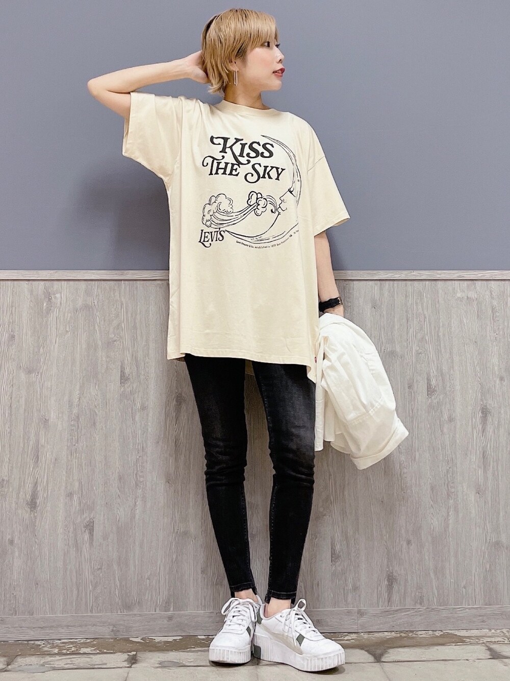 ベージュ系のTシャツ/カットソー、ブラック系のパンツ、ホワイト系のスニーカーを着用したレディースの春コーディネートの1枚目の写真