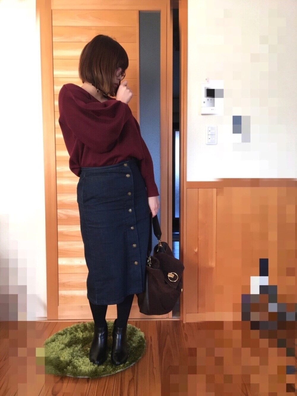 レッド系のニット/セーター、ブルー系のデニムスカート、ブラウン系のショルダーバッグを着用したレディースの冬コーディネートの1枚目の写真
