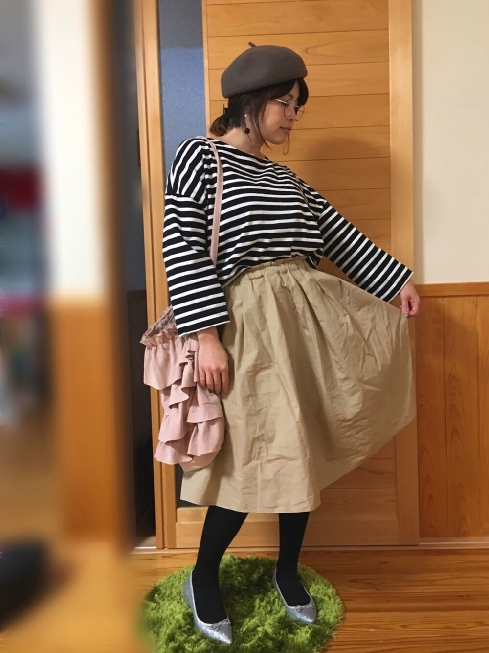 ベージュ系のスカート、シルバー系のバレエシューズ、ピンク系のトートバッグを着用したレディースの冬コーディネートの1枚目の写真