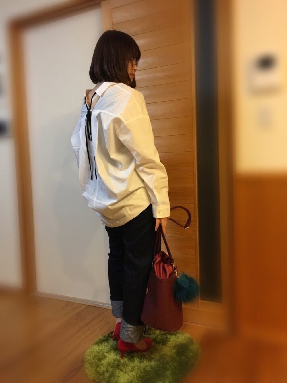 ホワイト系のシャツ/ブラウス、ブルー系のデニムパンツ、レッド系のショルダーバッグを着用したレディースの冬コーディネートの1枚目の写真