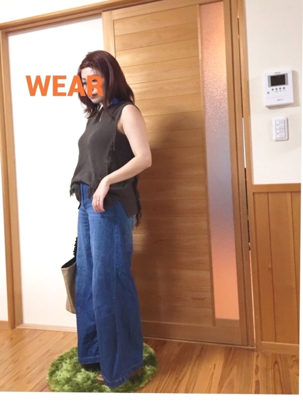 グリーン系のニット/セーター、ブルー系のデニムパンツ、ブラウン系のトートバッグを着用したレディースの夏コーディネートの1枚目の写真