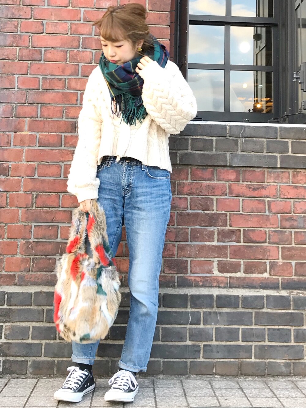 ホワイト系のカーディガン/ボレロ、ブルー系のデニムパンツ、オレンジ系のトートバッグを着用したレディースの冬コーディネートの1枚目の写真