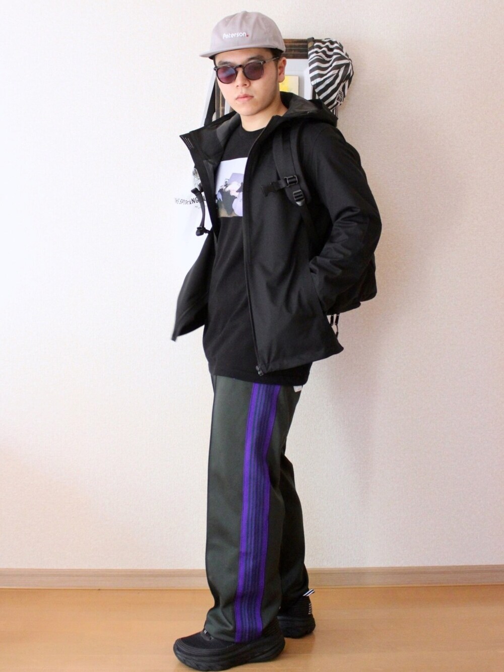 ブラック系のブルゾン、グリーン系のパンツ、ブラック系のスニーカーを着用したメンズの秋コーディネートの1枚目の写真