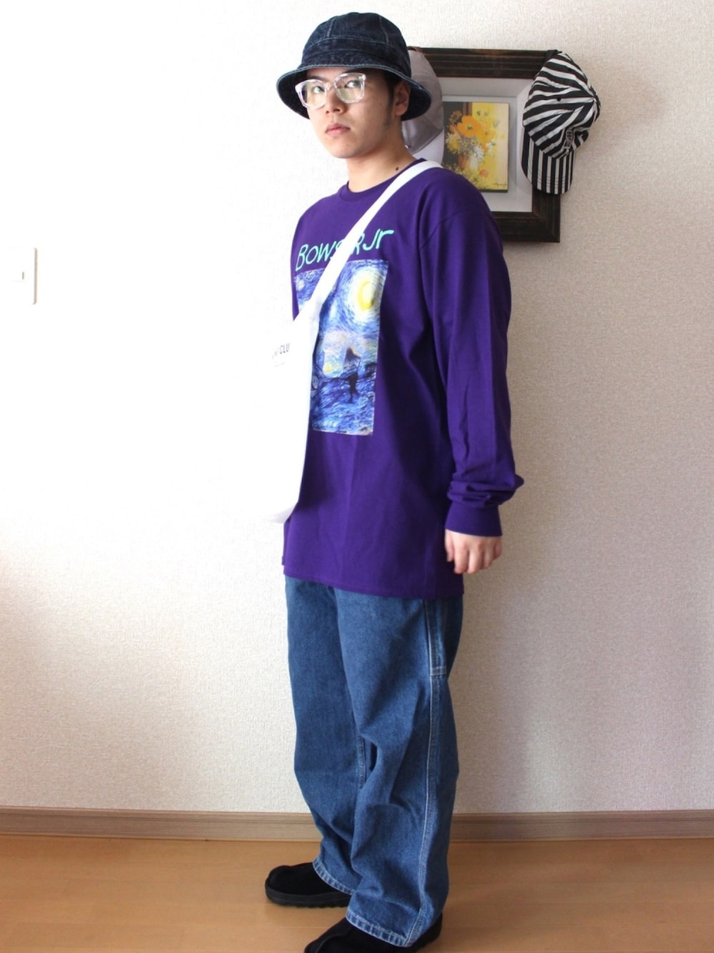 ブルー系のデニムパンツ、ブラック系のサンダル、ホワイト系のショルダーバッグを着用したメンズの秋コーディネートの1枚目の写真