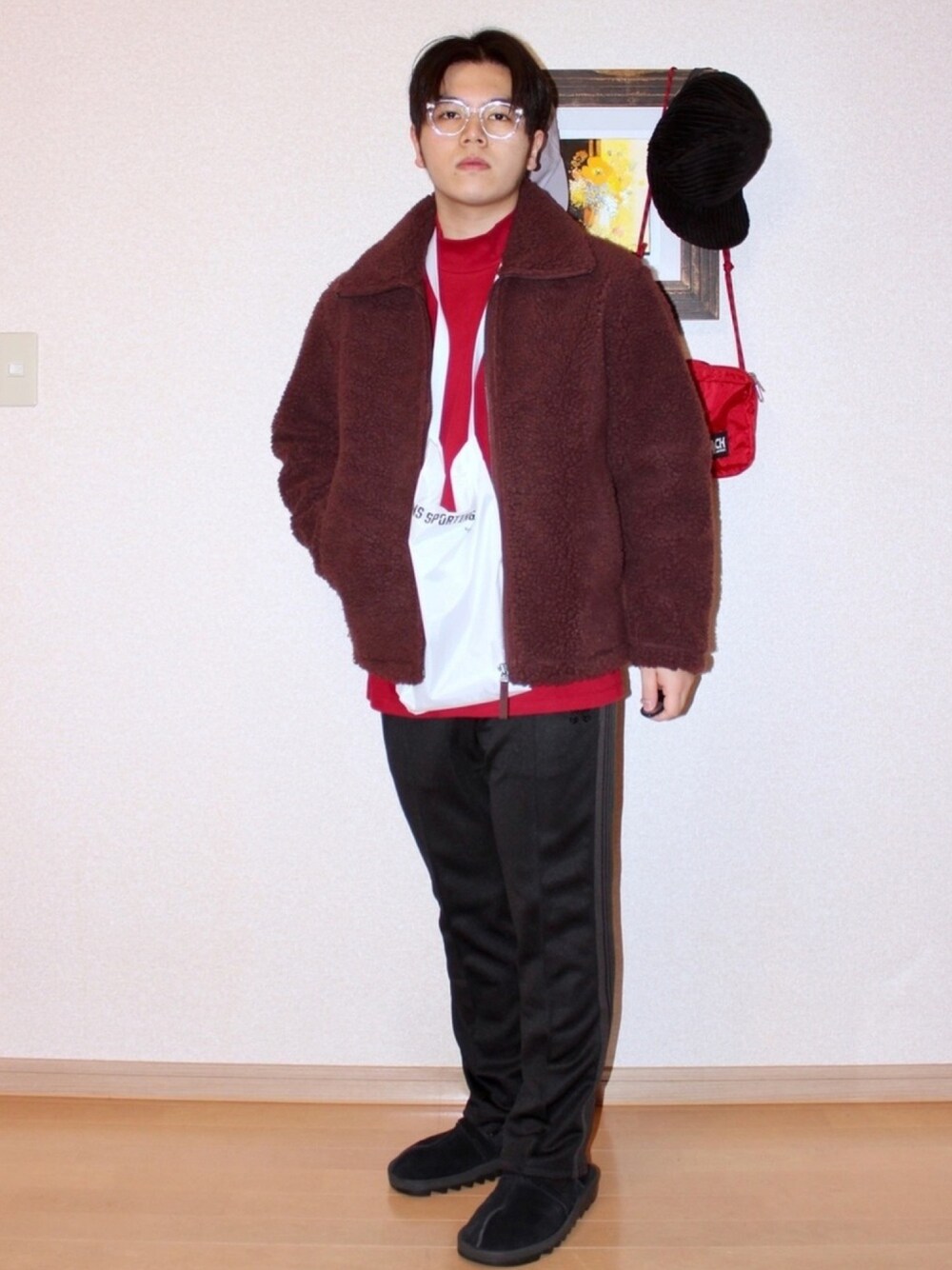 ブラウン系のブルゾン、レッド系のTシャツ/カットソー、ブラック系のパンツを着用したメンズの冬コーディネートの1枚目の写真