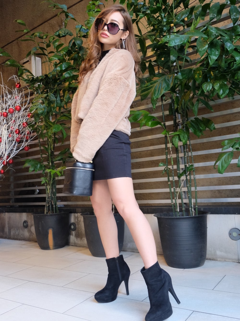 ベージュ系のテーラードジャケット、ブラック系のスカートを着用したレディースの冬コーディネートの1枚目の写真