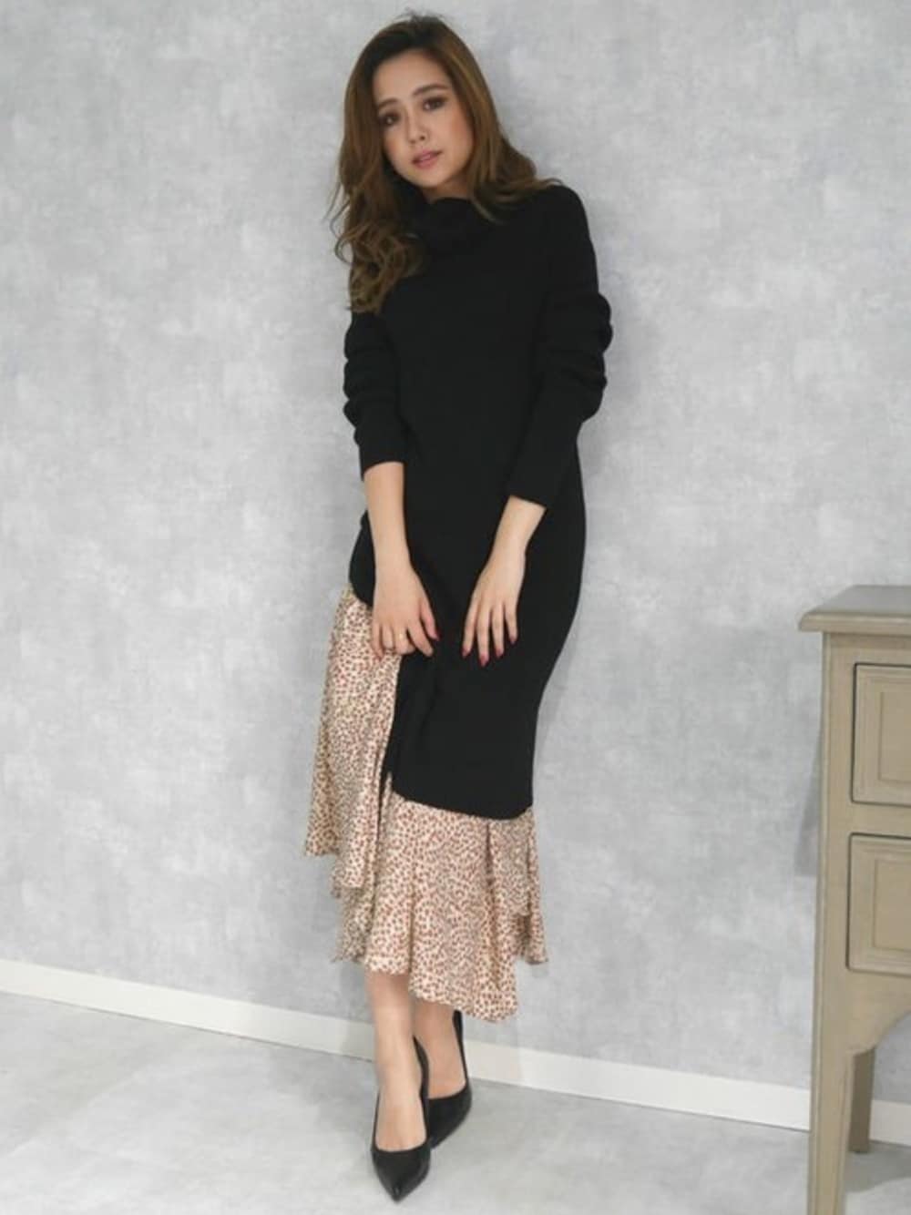 ホワイト系のスカート、ブラック系のパンプス、ブラック系のワンピースを着用したレディースの冬コーディネートの1枚目の写真