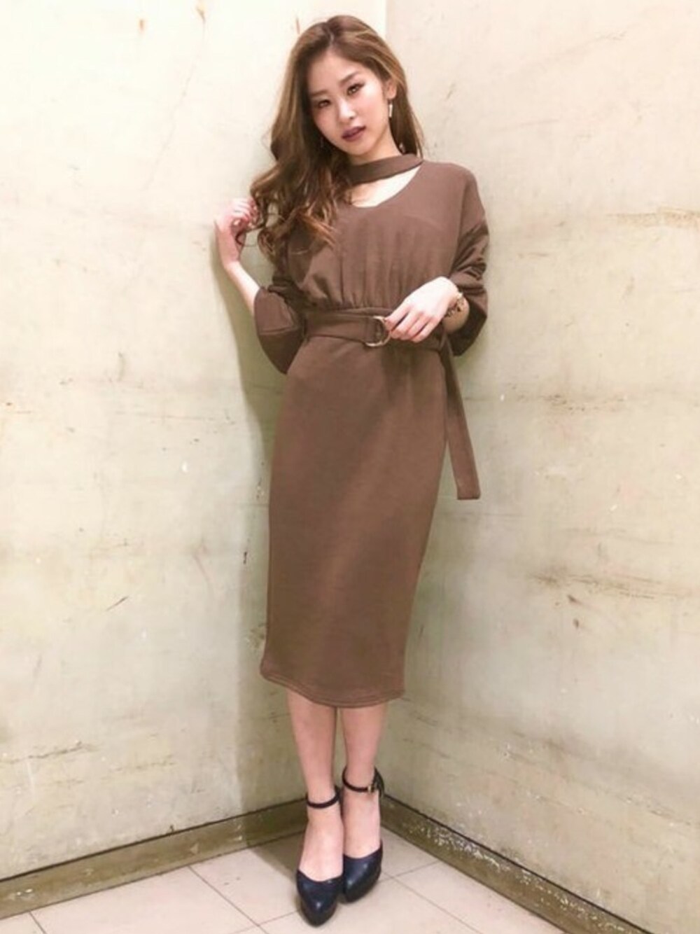 ブラック系のパンプス、ブラウン系のワンピースを着用したレディースの冬コーディネートの1枚目の写真