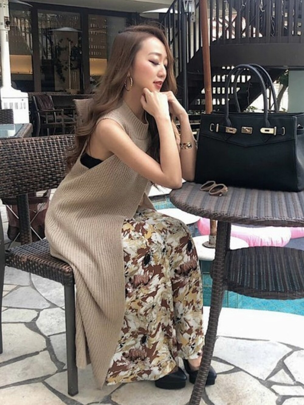 ブラウン系のスカート、ベージュ系のワンピース、ブラック系のハンドバッグを着用したレディースの春コーディネートの1枚目の写真