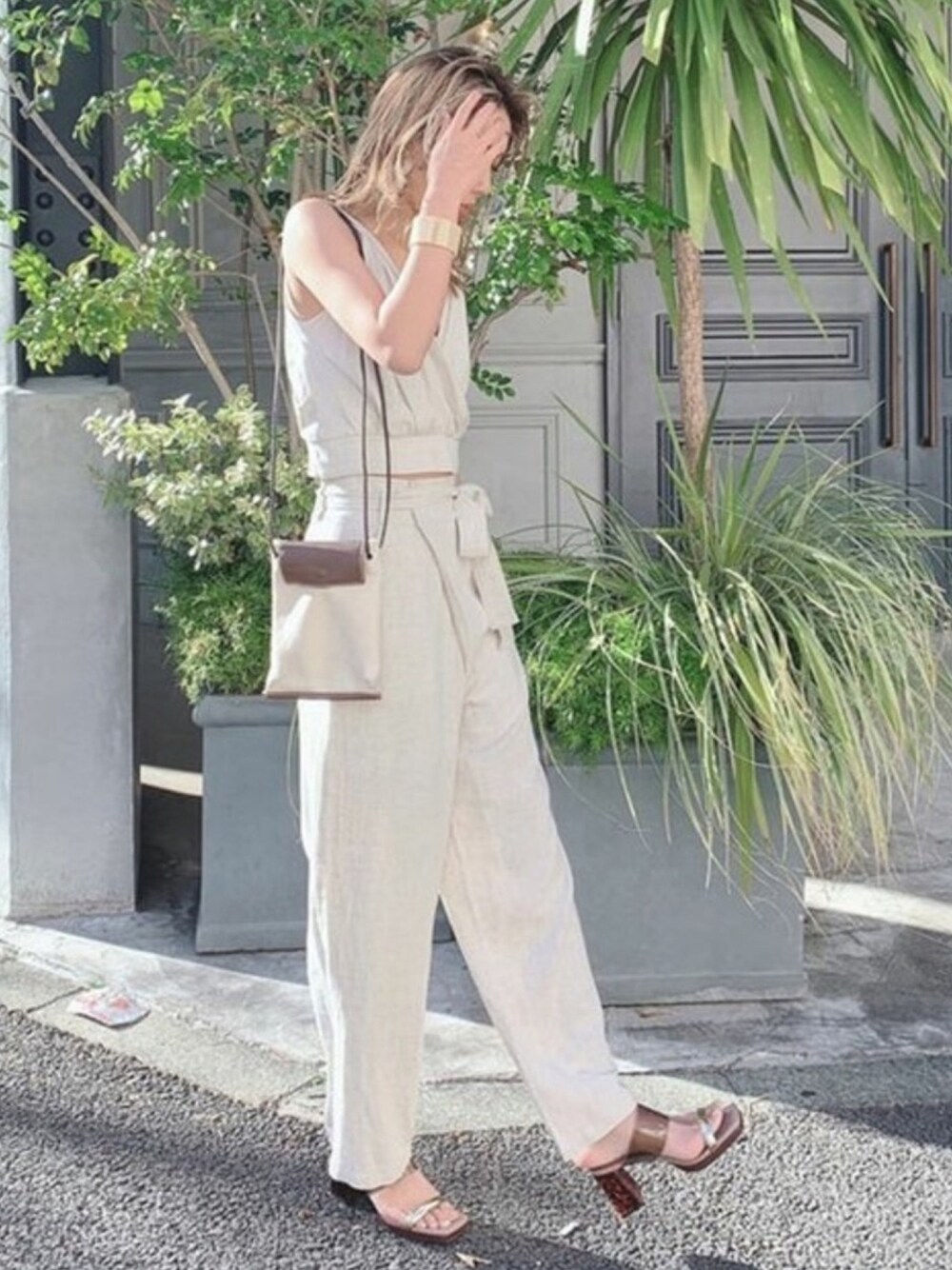 ベージュ系のその他パンツ、ベージュ系のタンクトップ、その他のサンダルを着用したレディースの春コーディネートの1枚目の写真