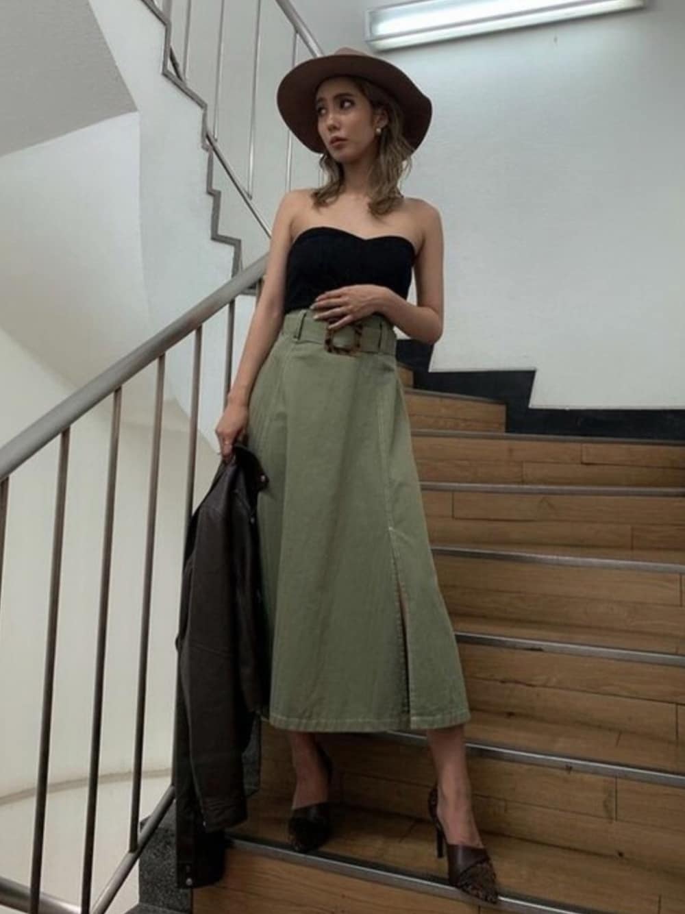 グリーン系のスカート、ブラック系のチューブトップを着用したレディースの夏コーディネートの1枚目の写真