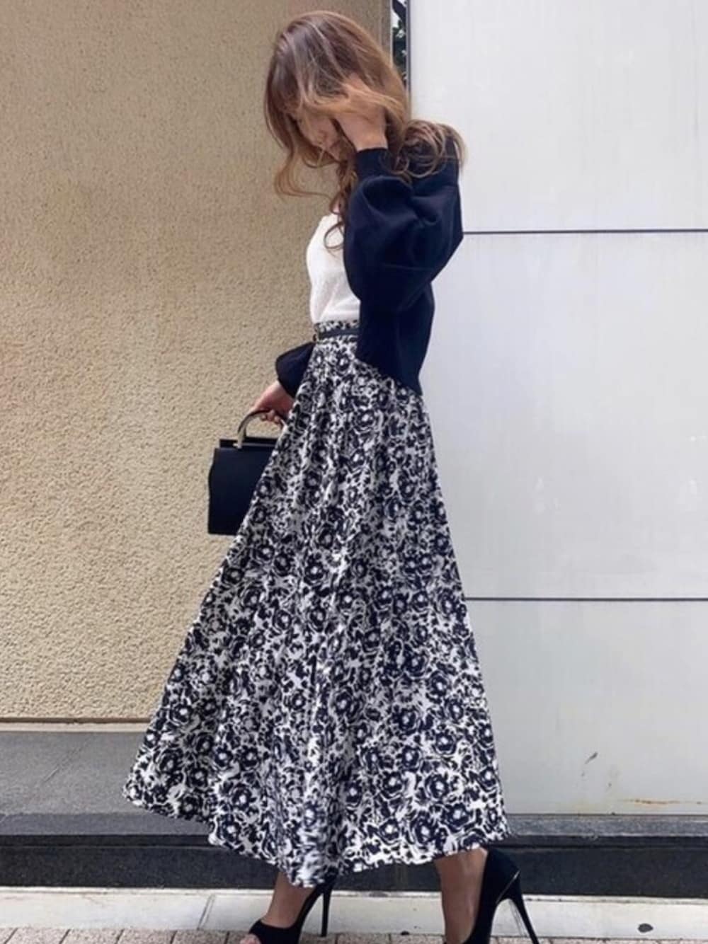 ブラック系のスカート、ブラック系のカーディガン/ボレロ、ホワイト系のチューブトップを着用したレディースの秋コーディネートの1枚目の写真