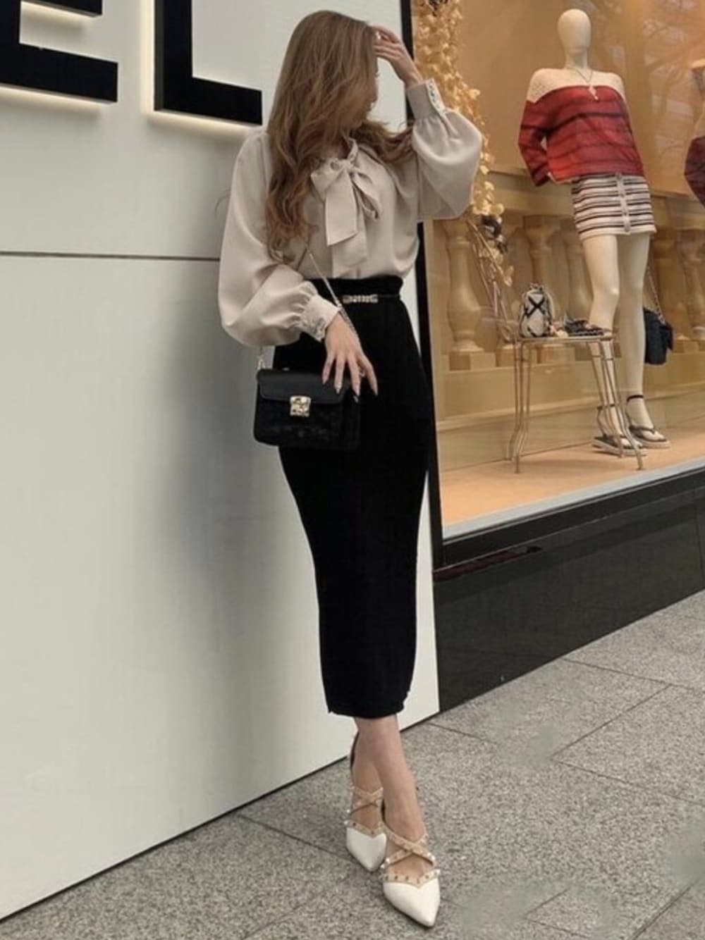ブラック系のスカート、ホワイト系のシャツ/ブラウス、ブラック系のハンドバッグを着用したレディースの春コーディネートの1枚目の写真