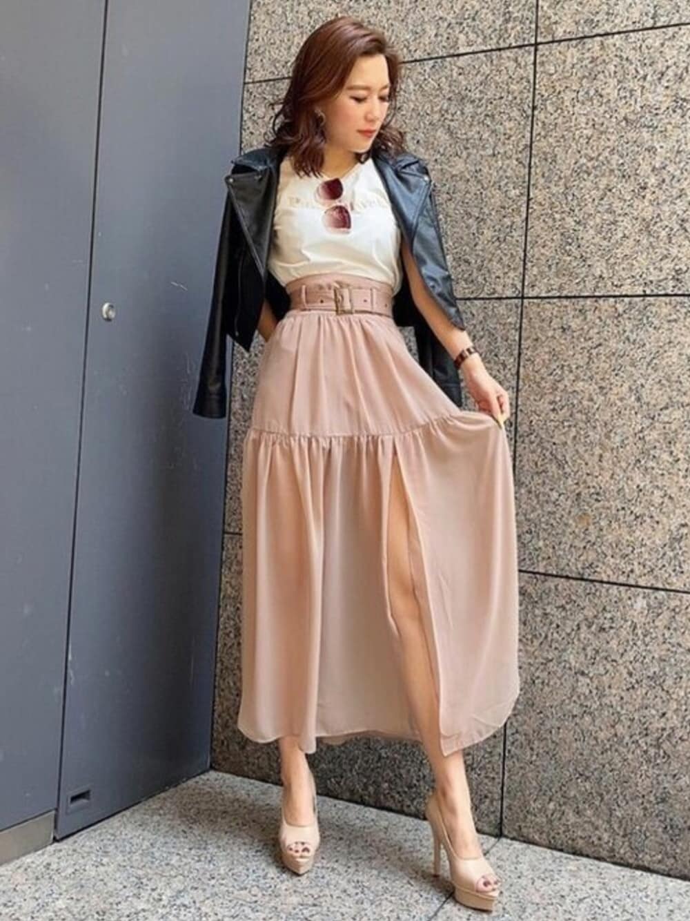 ブラック系のライダースジャケット、ブラウン系のスカート、ホワイト系のTシャツ/カットソーを着用したレディースの春コーディネートの1枚目の写真