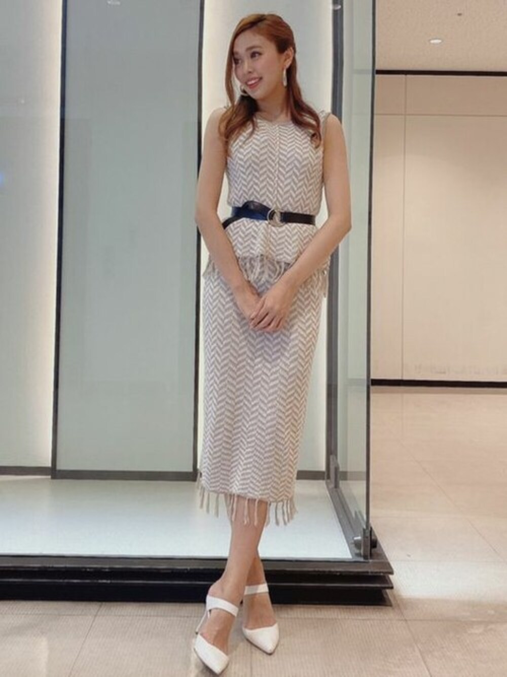 グレー系のニット/セーター、グレー系のスカートを着用したレディースの夏コーディネートの1枚目の写真