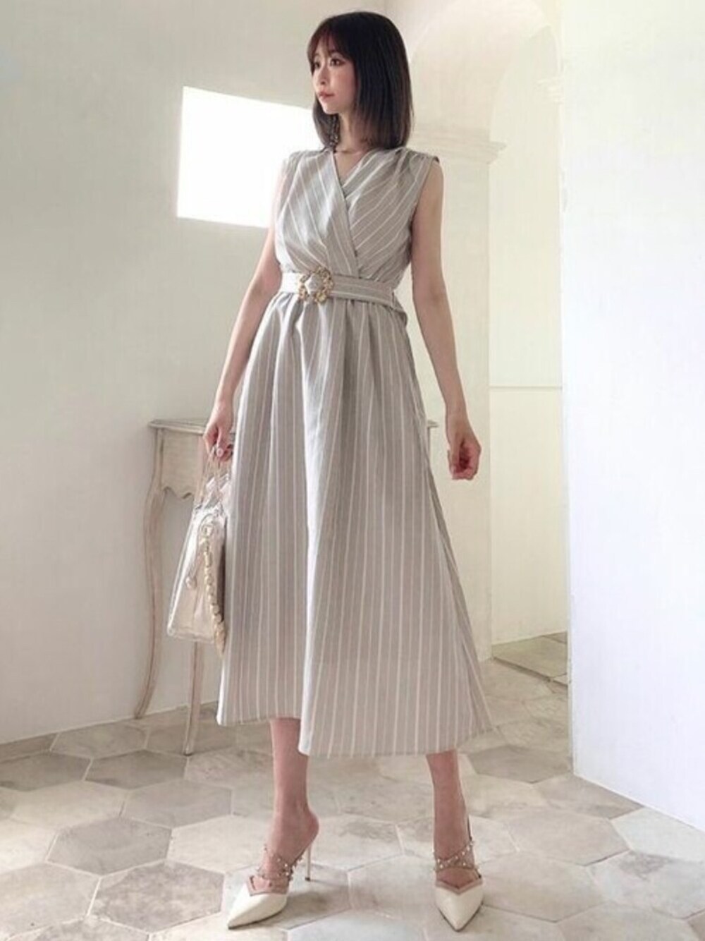 ベージュ系のワンピース、ベージュ系のショルダーバッグを着用したレディースの夏コーディネートの1枚目の写真