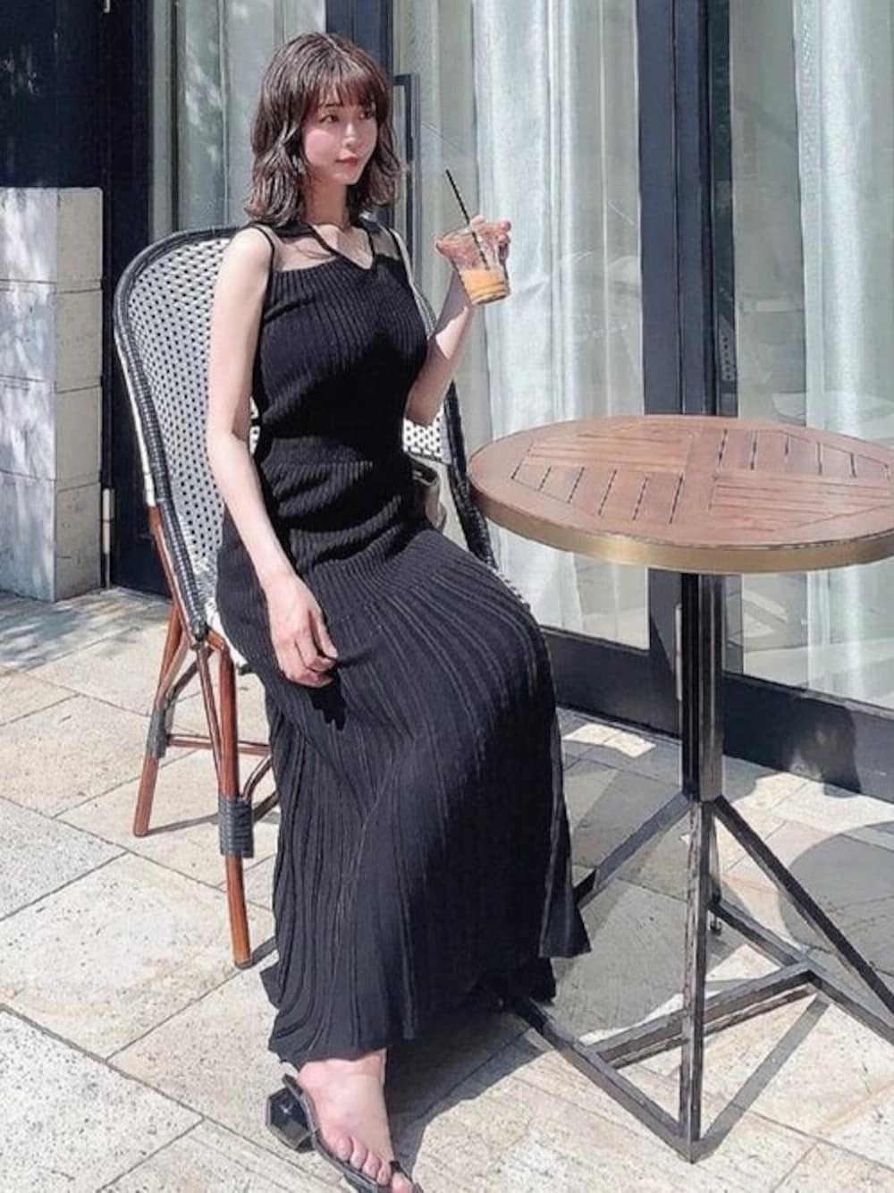 ブラック系のワンピースを着用したレディースの夏コーディネートの1枚目の写真