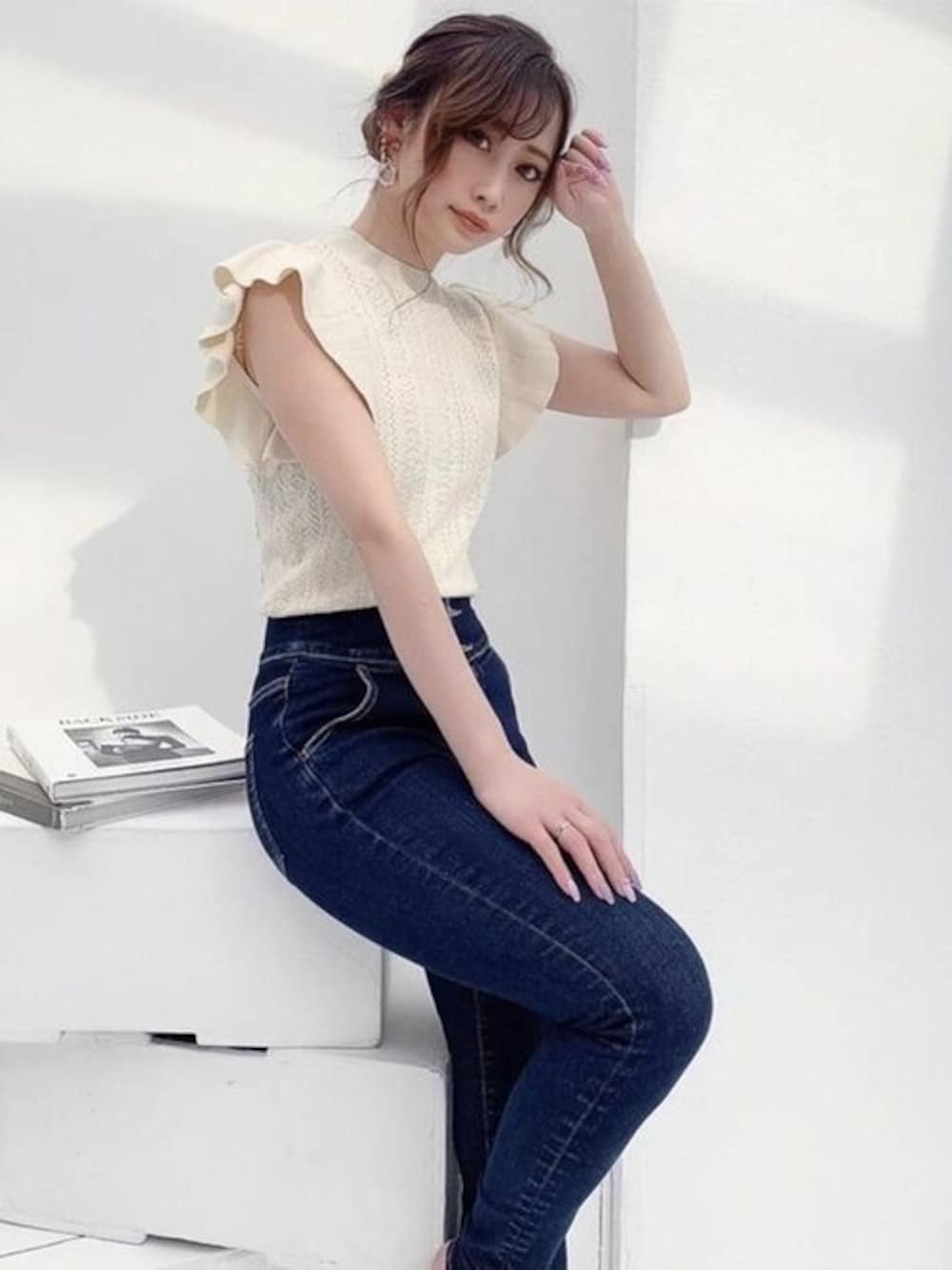 ホワイト系のニット/セーター、ブルー系のデニムパンツを着用したレディースの夏コーディネートの1枚目の写真