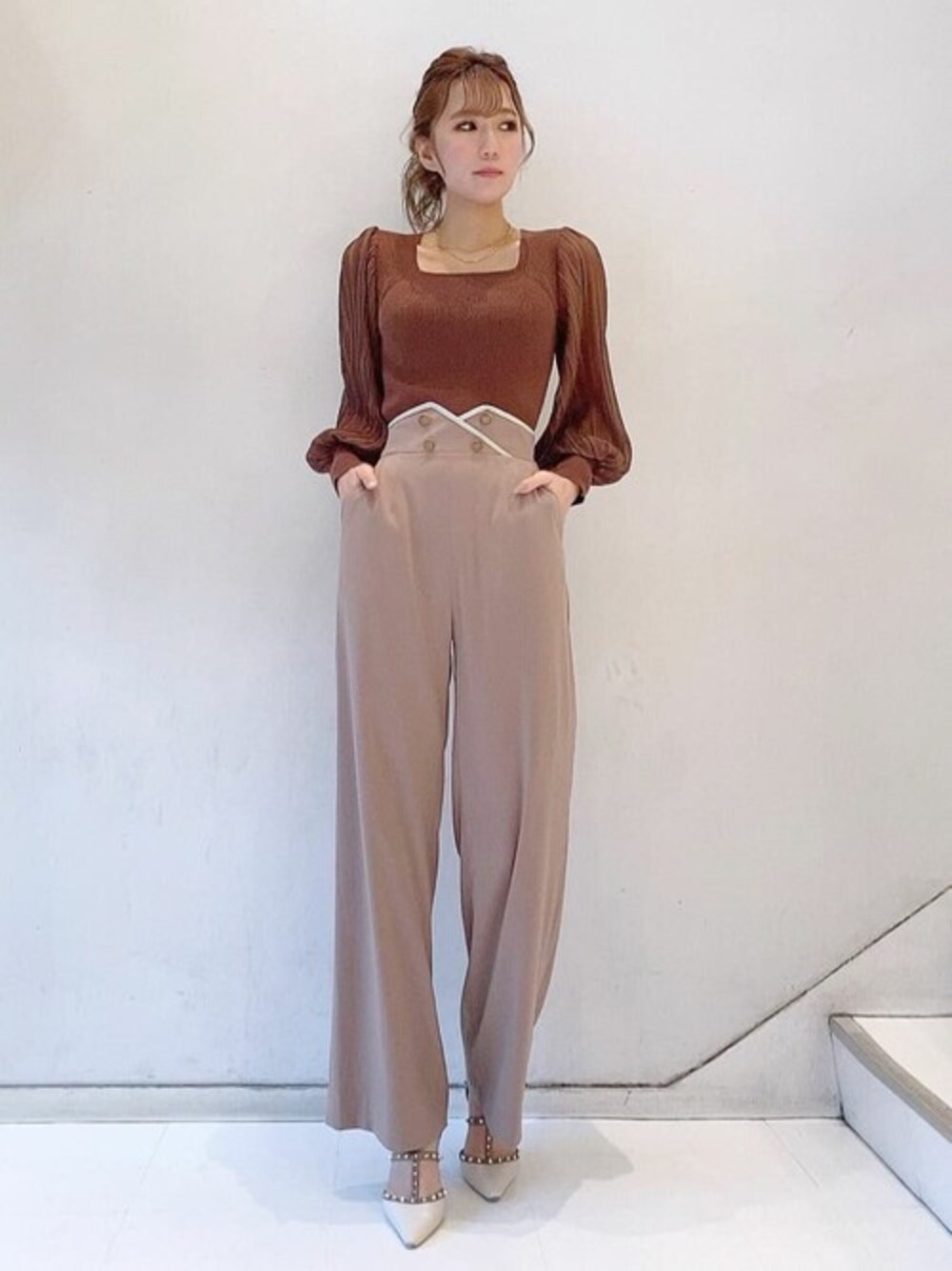 ブラウン系のニット/セーター、ベージュ系のその他パンツ、ホワイト系のパンプスを着用したレディースの冬コーディネートの1枚目の写真