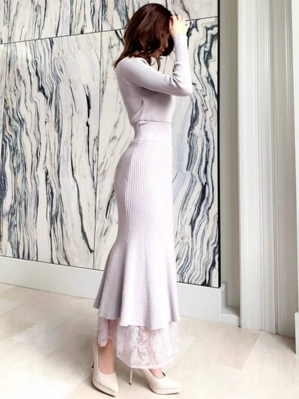 パープル系のワンピース、ホワイト系のパンプスを着用したレディースの冬コーディネートの1枚目の写真