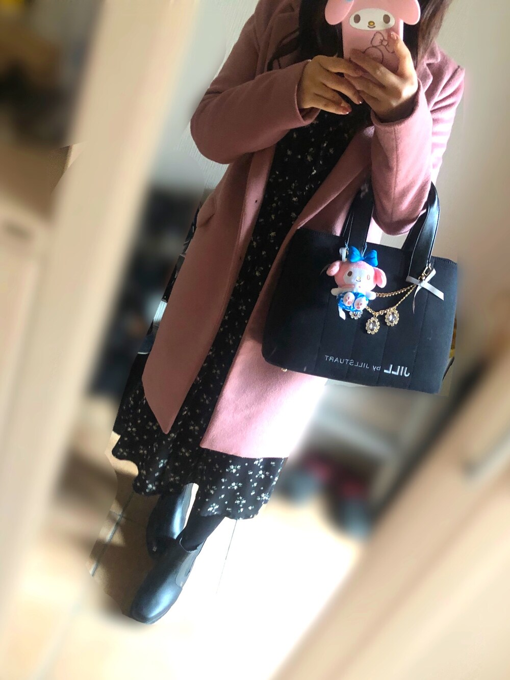 ピンク系のチェスターコート、ブラック系のワンピース、ブラック系のトートバッグを着用したレディースの冬コーディネートの1枚目の写真