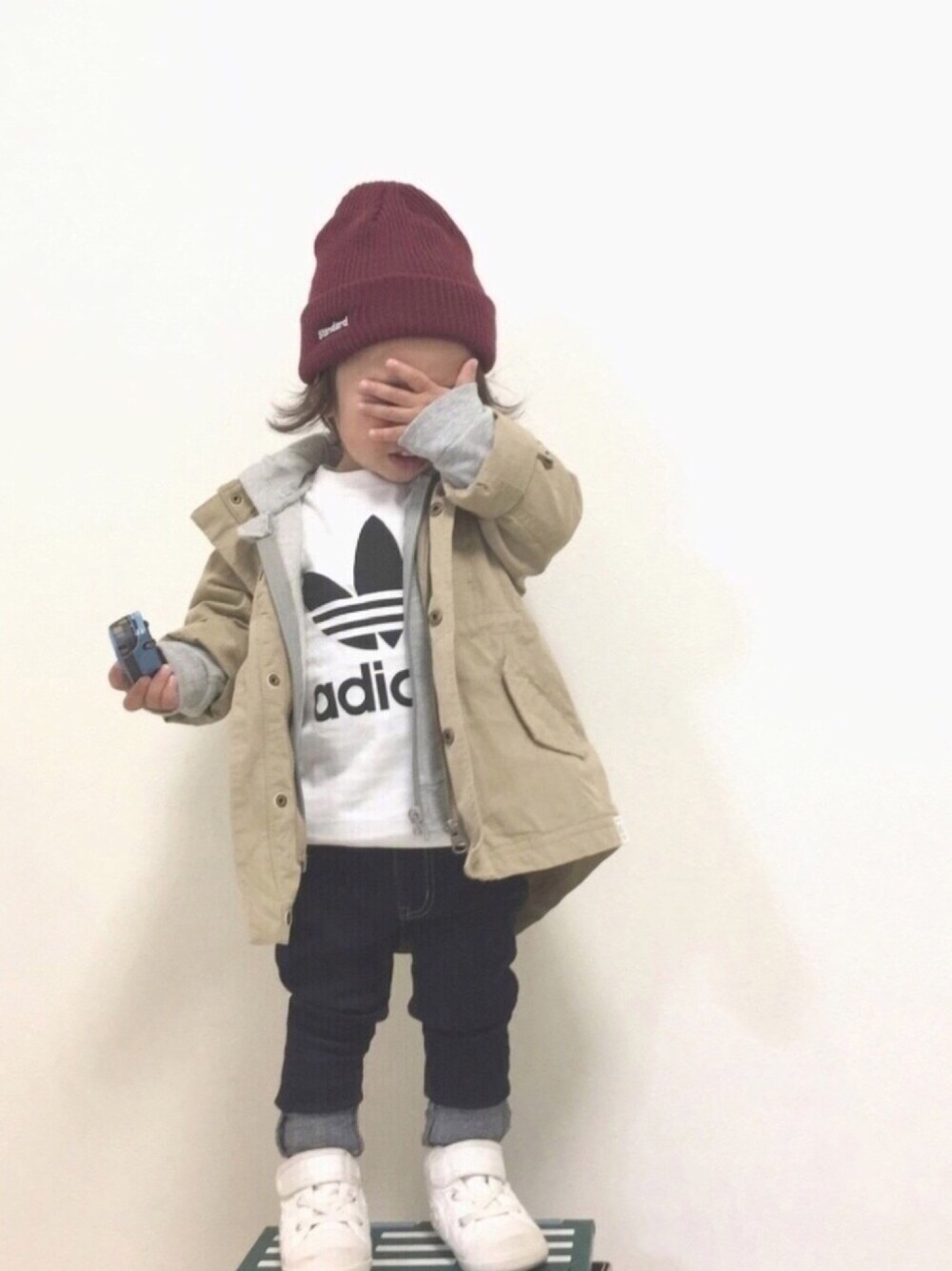 ホワイト系のTシャツ/カットソー、ベージュ系のモッズコート、ブルー系のデニムパンツを着用したキッズの冬コーディネートの1枚目の写真
