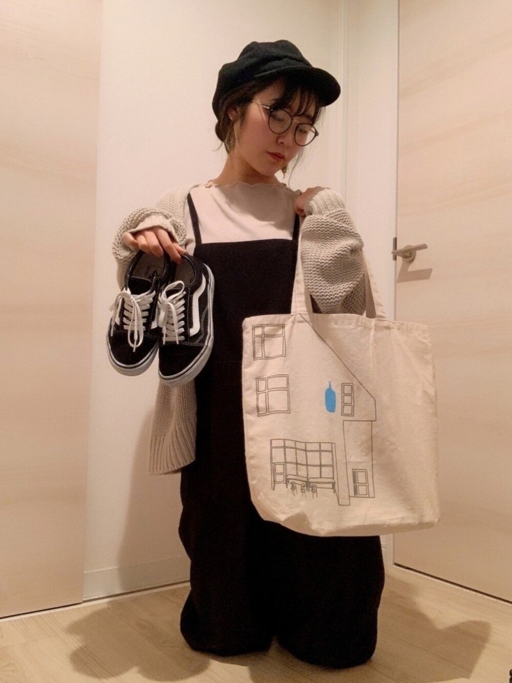 ベージュ系のカーディガン/ボレロ、ブラック系のつなぎ/オールインワン、ブラック系のスニーカーを着用したレディースの冬コーディネートの1枚目の写真