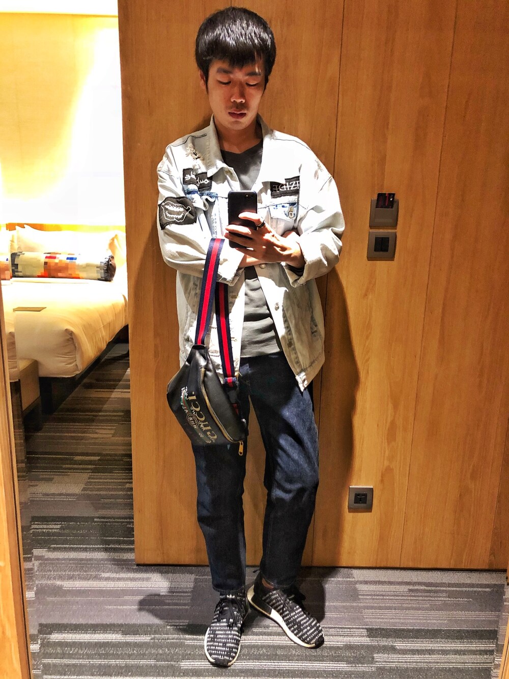 ブラック系のスニーカー、ブルー系のデニムパンツ、ブルー系のデニムジャケットを着用したメンズの春コーディネートの1枚目の写真