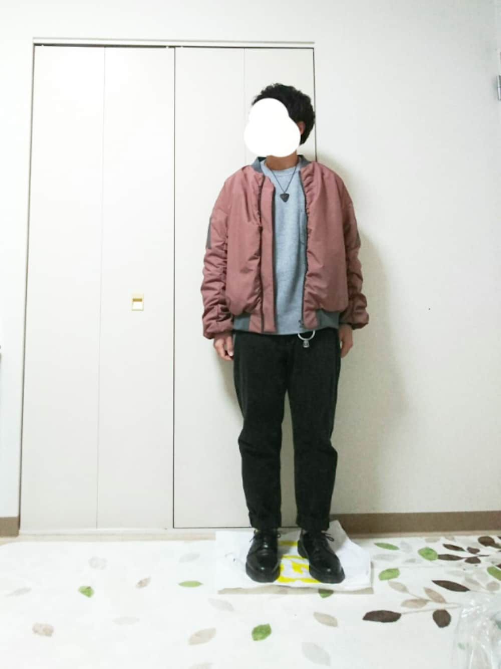 グレー系のニット/セーター、ホワイト系のTシャツ/カットソー、ブラック系のデニムパンツを着用したメンズの秋コーディネートの1枚目の写真