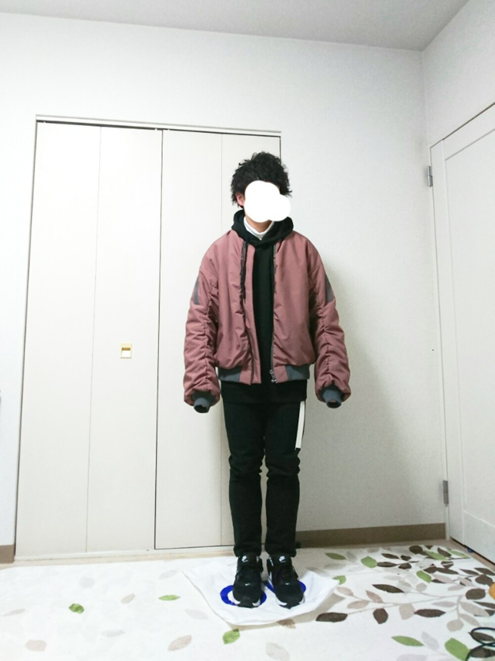 ブラック系のパーカー、ホワイト系のTシャツ/カットソー、ブラック系のデニムパンツを着用したメンズの冬コーディネートの1枚目の写真