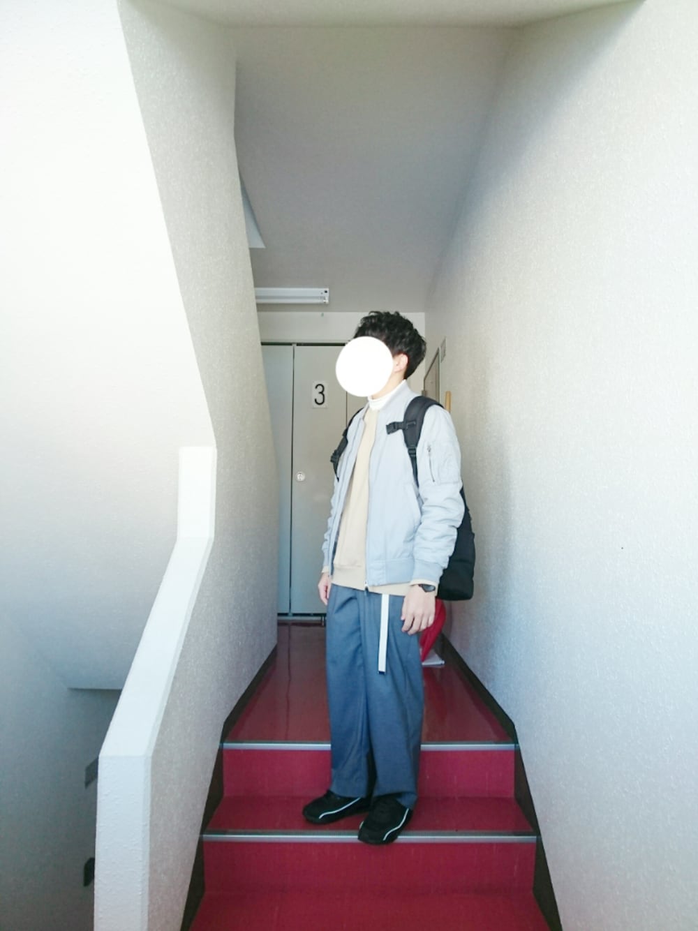 グレー系のミリタリージャケット、ベージュ系のスウェット、ホワイト系のTシャツ/カットソーを着用したメンズの冬コーディネートの1枚目の写真