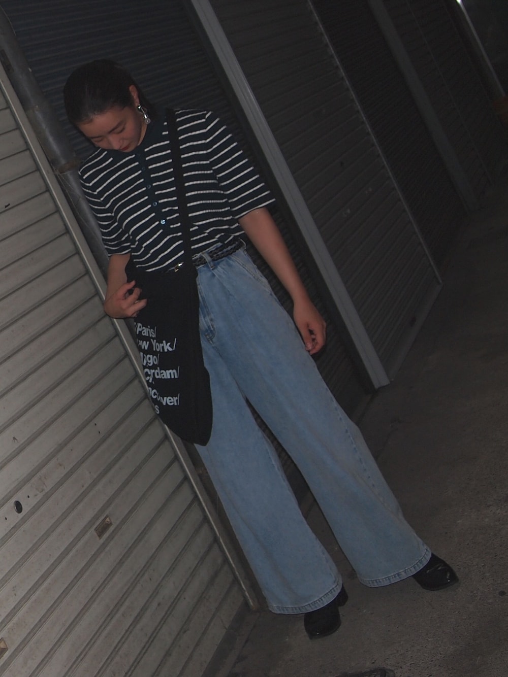 グリーン系のポロシャツ、ブルー系のデニムパンツ、ブラック系のトートバッグを着用したレディースの夏コーディネートの1枚目の写真