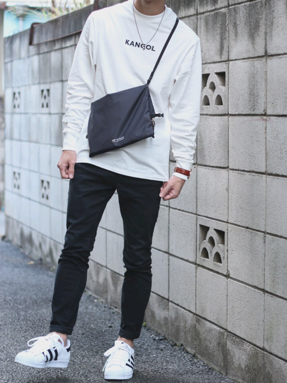 ホワイト系のスニーカー、ブラック系のその他パンツ、ブラック系のショルダーバッグを着用したメンズの秋コーディネートの1枚目の写真