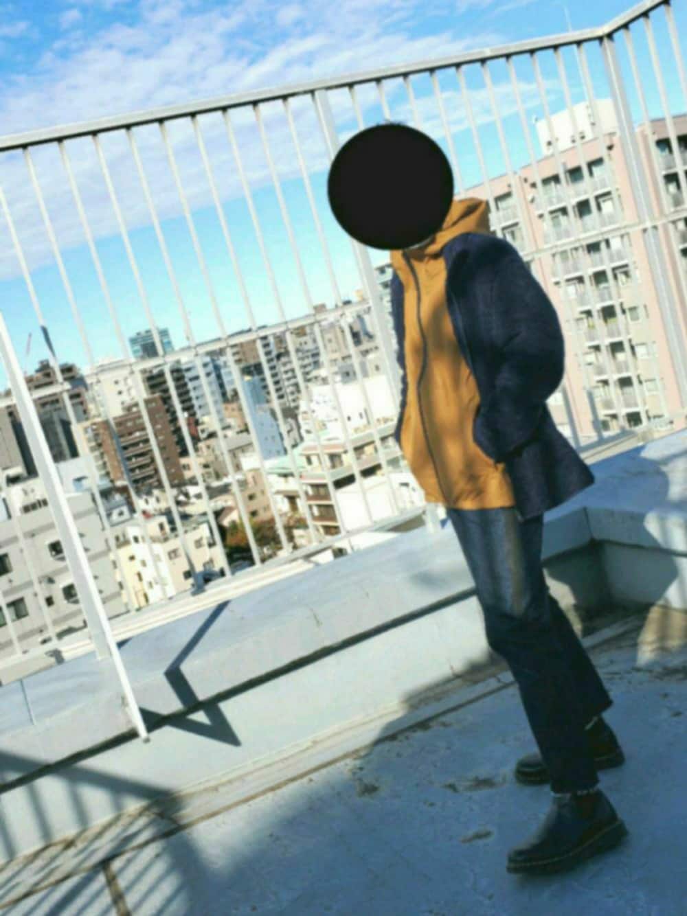 ブラウン系のパーカー、ブルー系のその他アウター、ブラック系のブーツを着用したメンズの冬コーディネートの1枚目の写真