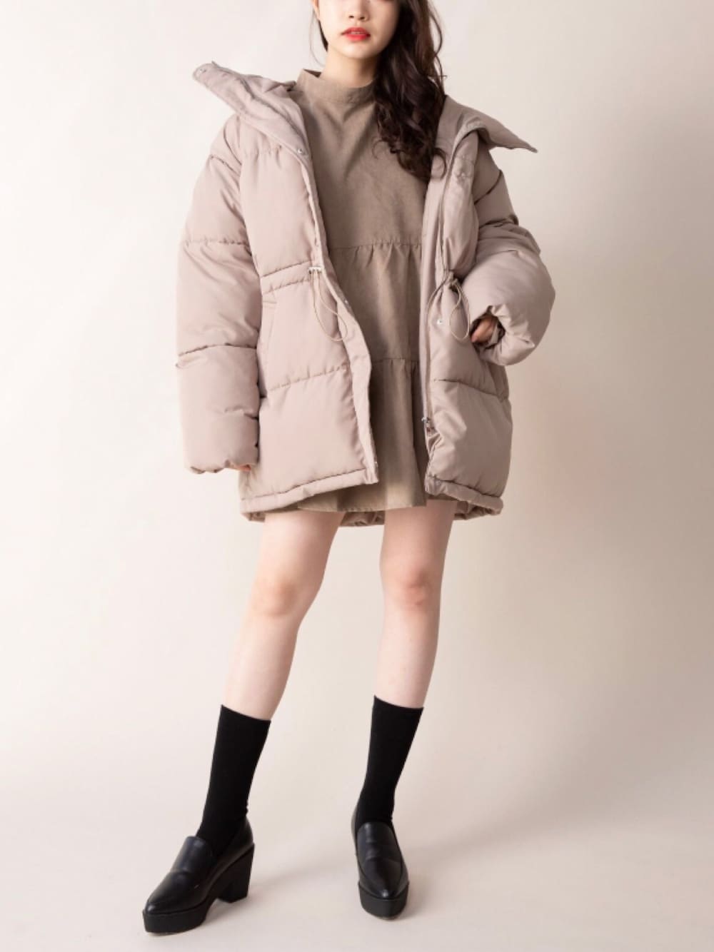 ベージュ系のダウンジャケット/コート、ブラウン系のチュニックを着用したレディースの秋コーディネートの1枚目の写真