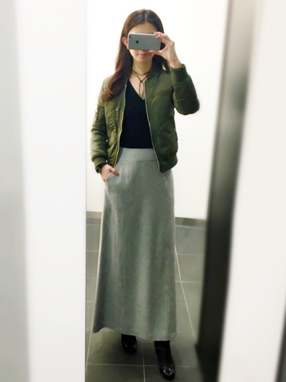 グレー系のスカート、ブラック系のシューズを着用したレディースの冬コーディネートの1枚目の写真