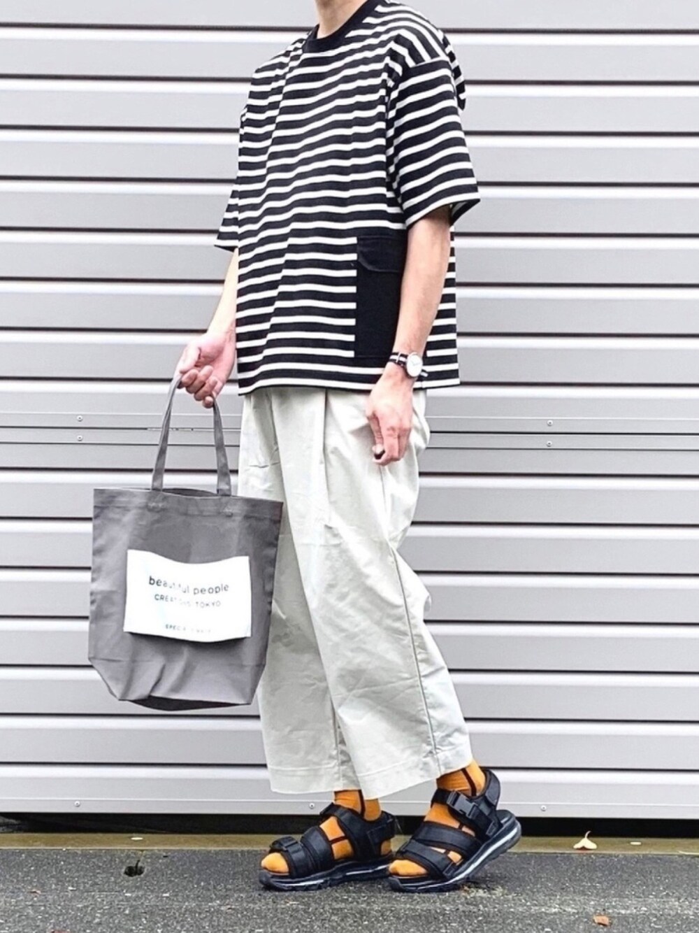 ブラック系のTシャツ/カットソー、グレー系のトートバッグ、ホワイト系のその他パンツを着用したメンズの春コーディネートの1枚目の写真