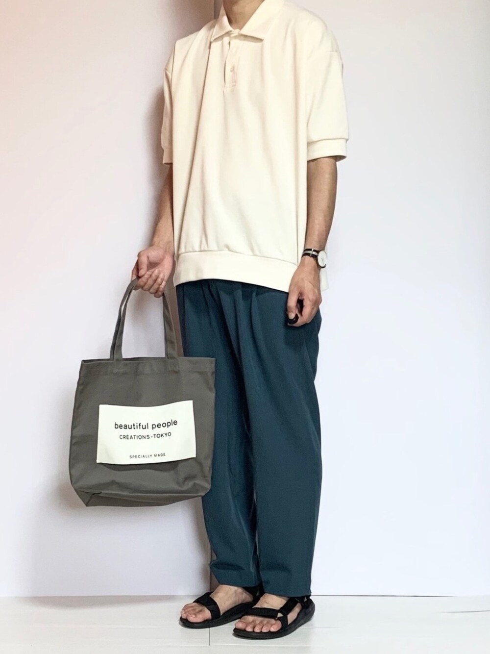 ホワイト系のポロシャツ、ブルー系のその他パンツ、ブラック系のサンダルを着用したメンズの夏コーディネートの1枚目の写真