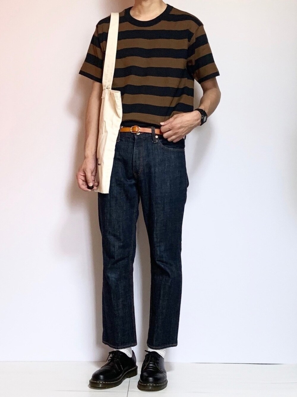 ブラウン系のTシャツ/カットソー、ホワイト系のトートバッグ、ブラック系のブーツを着用したメンズの夏コーディネートの1枚目の写真