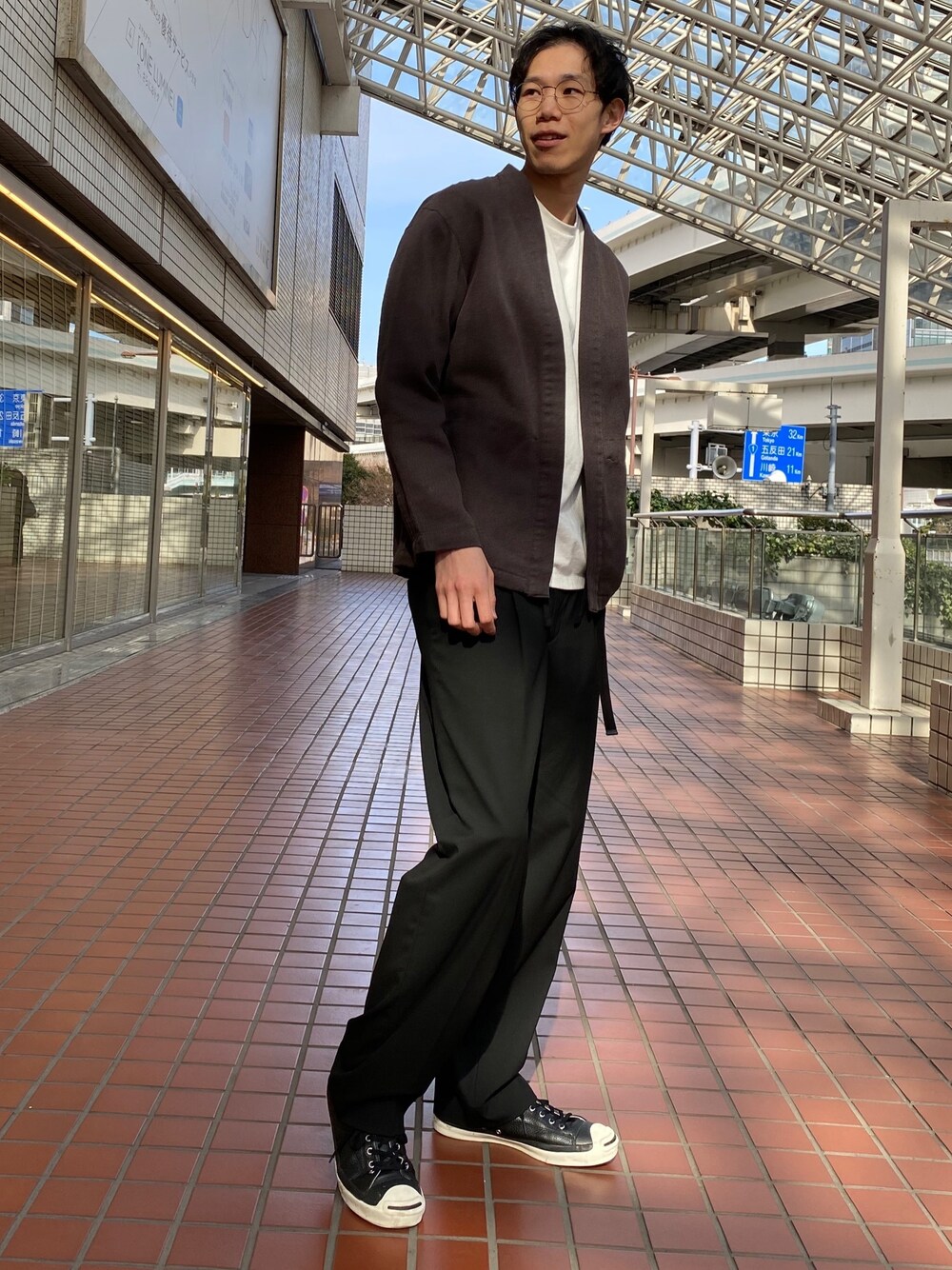 ブラック系のブルゾン、ブラック系のスラックス、ホワイト系のTシャツ/カットソーを着用したメンズの春コーディネートの1枚目の写真