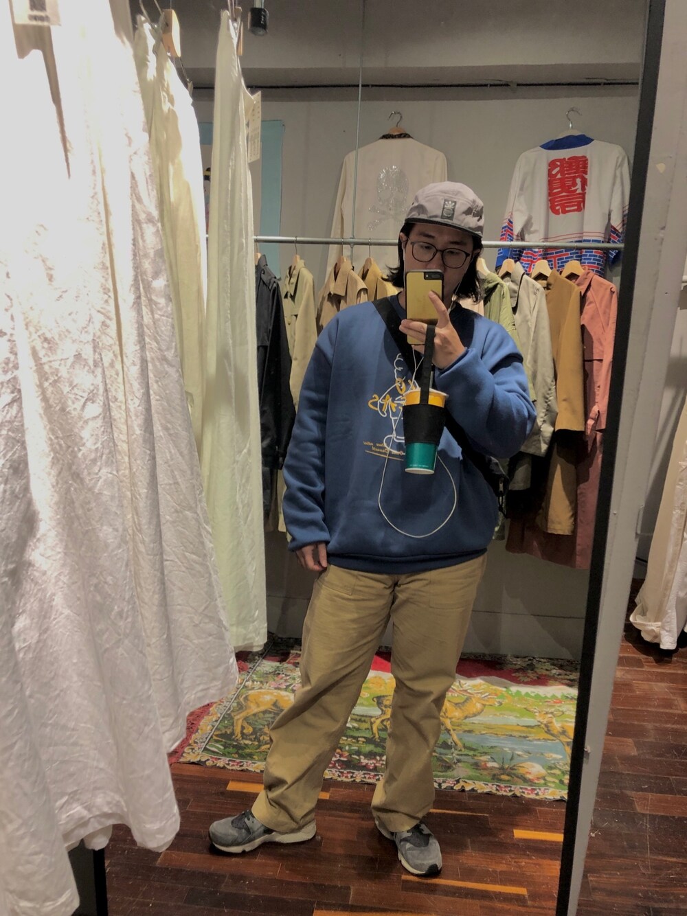 イエロー系のチノパンツ、グレー系のスニーカー、グレー系のキャップを着用したメンズの秋コーディネートの1枚目の写真