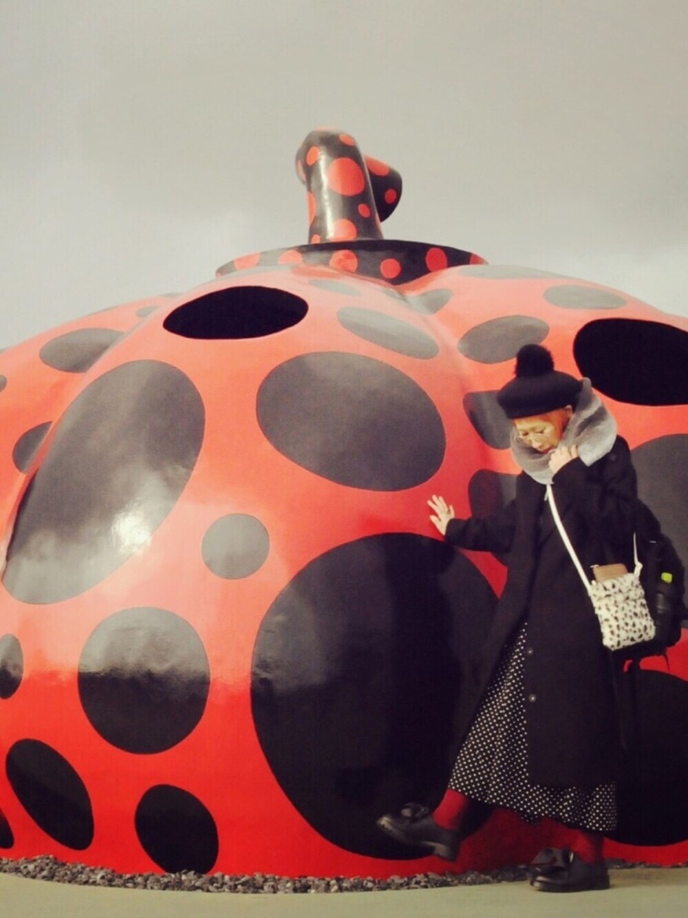 ブラック系のチェスターコート、ブラック系のシューズ、ブラック系のハンチング/ベレー帽を着用したレディースの冬コーディネートの1枚目の写真