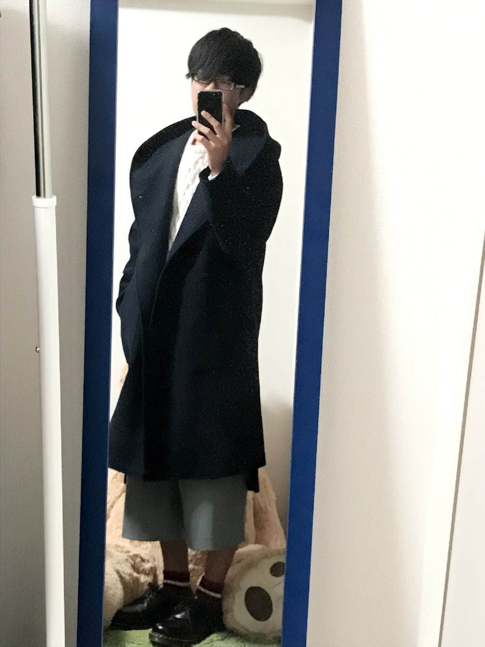 ブルー系のチェスターコート、ホワイト系のニット/セーター、グレー系のその他パンツを着用したメンズの冬コーディネートの1枚目の写真