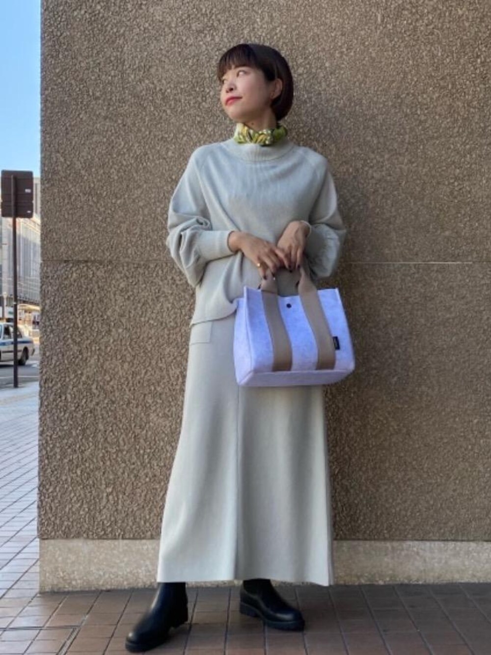 グリーン系のニット/セーター、ブラック系のブーツ、グリーン系のスカートを着用したレディースの秋コーディネートの1枚目の写真