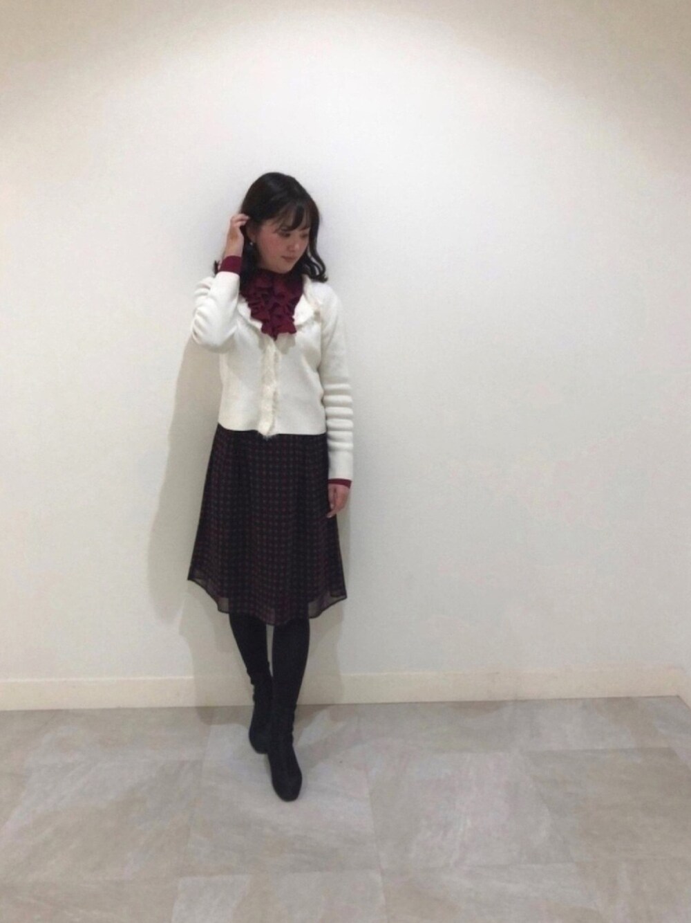 レッド系のスカート、レッド系のシャツ/ブラウス、ホワイト系のカーディガン/ボレロを着用したレディースの冬コーディネートの1枚目の写真