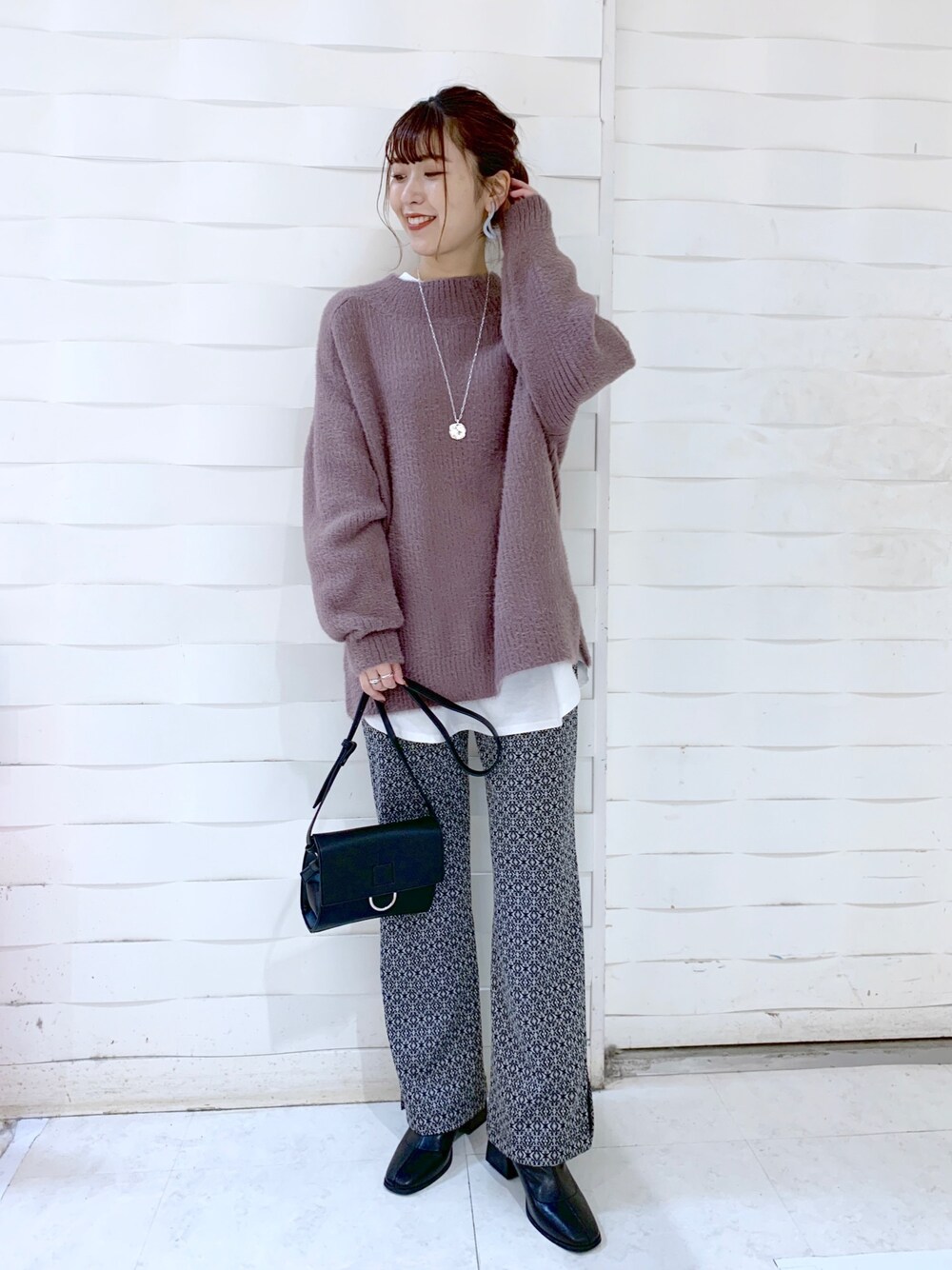 ブラウン系のニット/セーター、ブラック系のその他パンツ、ブラック系のブーツを着用したレディースの冬コーディネートの1枚目の写真