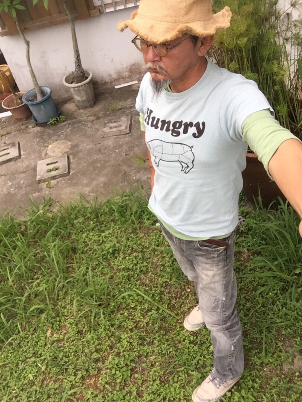 グレー系のスニーカー、ブルー系のTシャツ/カットソー、ブルー系のデニムパンツを着用したメンズの春コーディネートの1枚目の写真