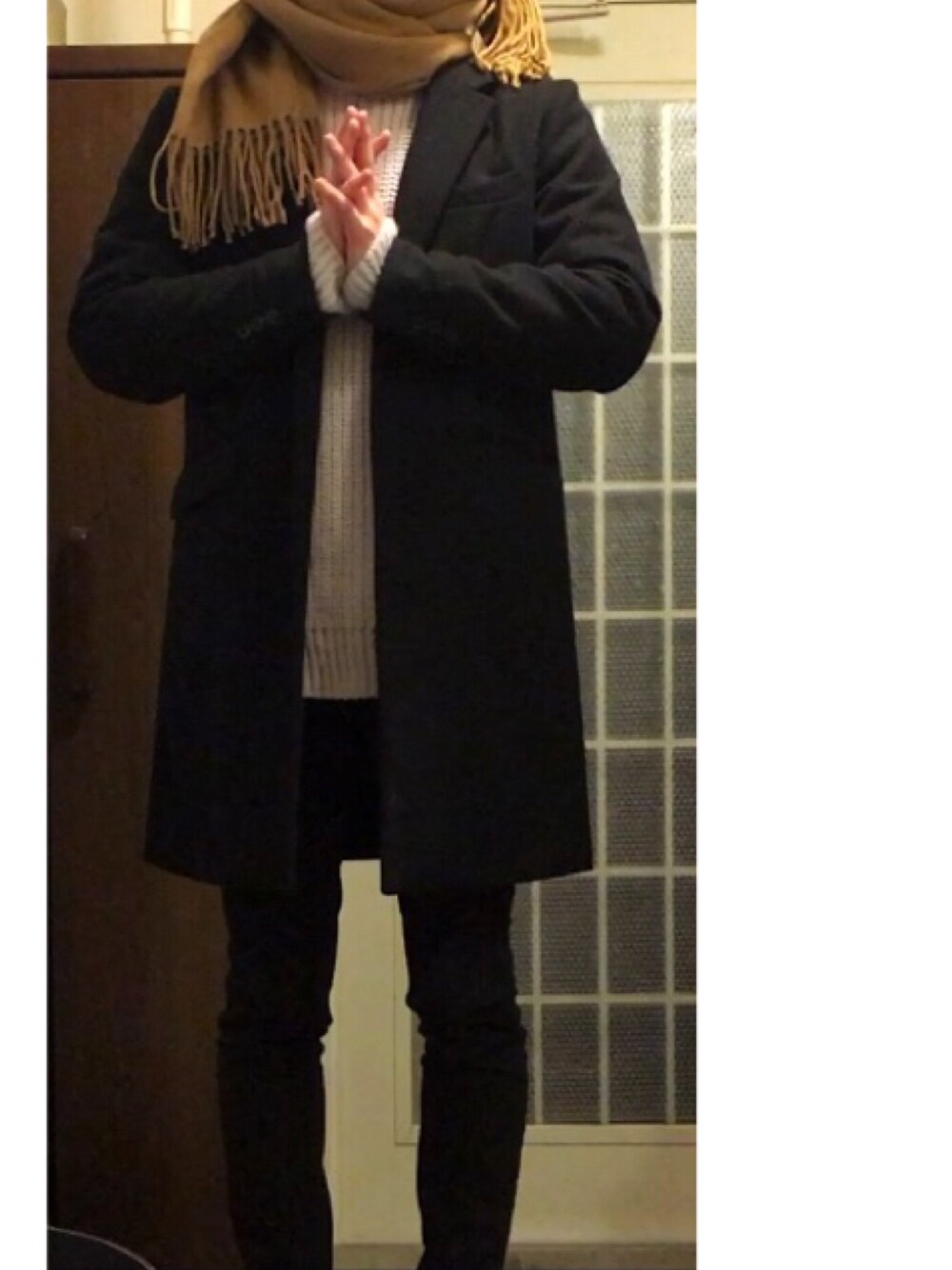 ブラック系のチェスターコート、グレー系のニット/セーター、ブラック系のパンツを着用したメンズの秋コーディネートの1枚目の写真