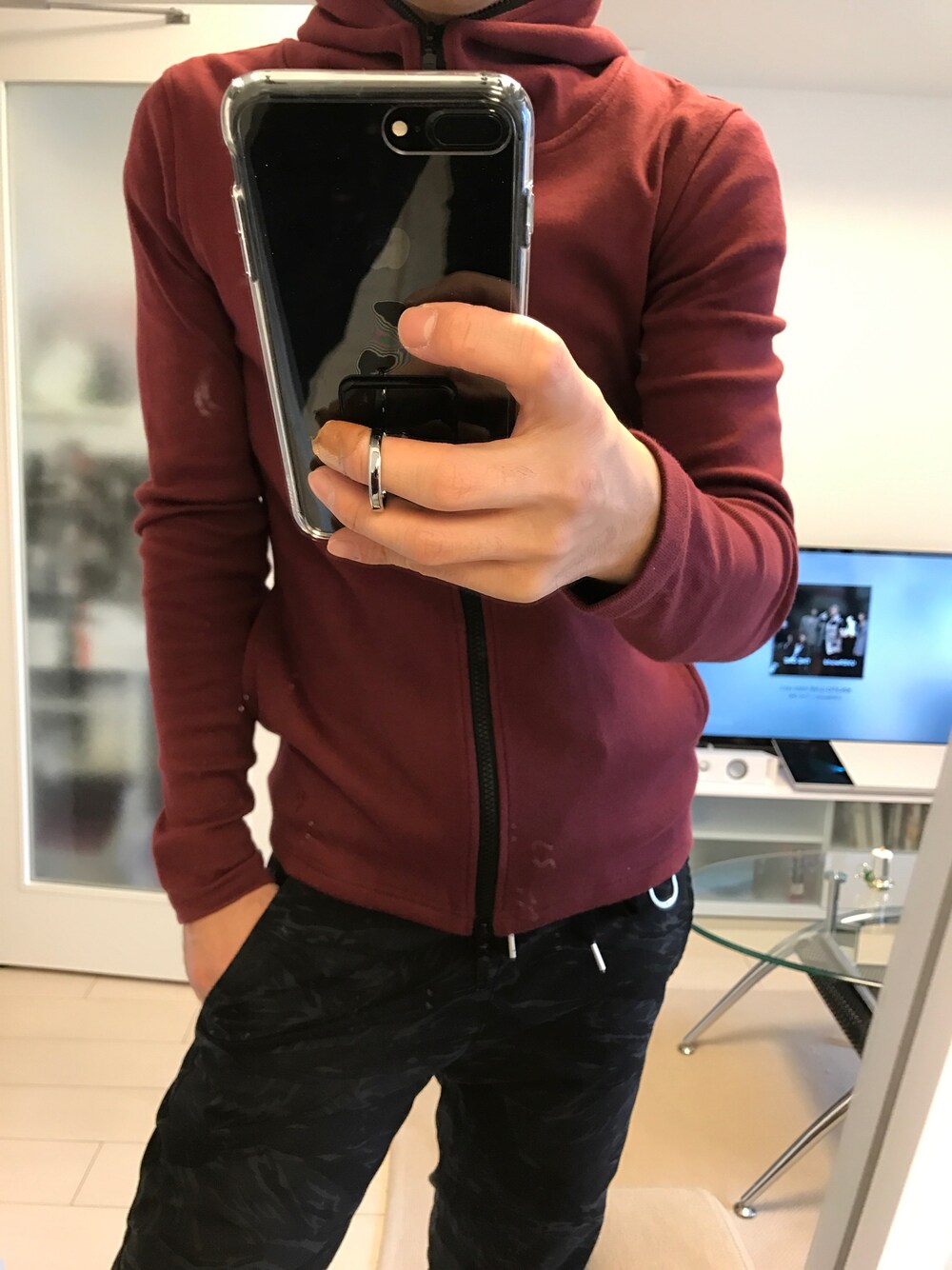 レッド系のパーカー、ブラック系のその他パンツを着用したメンズの冬コーディネートの1枚目の写真