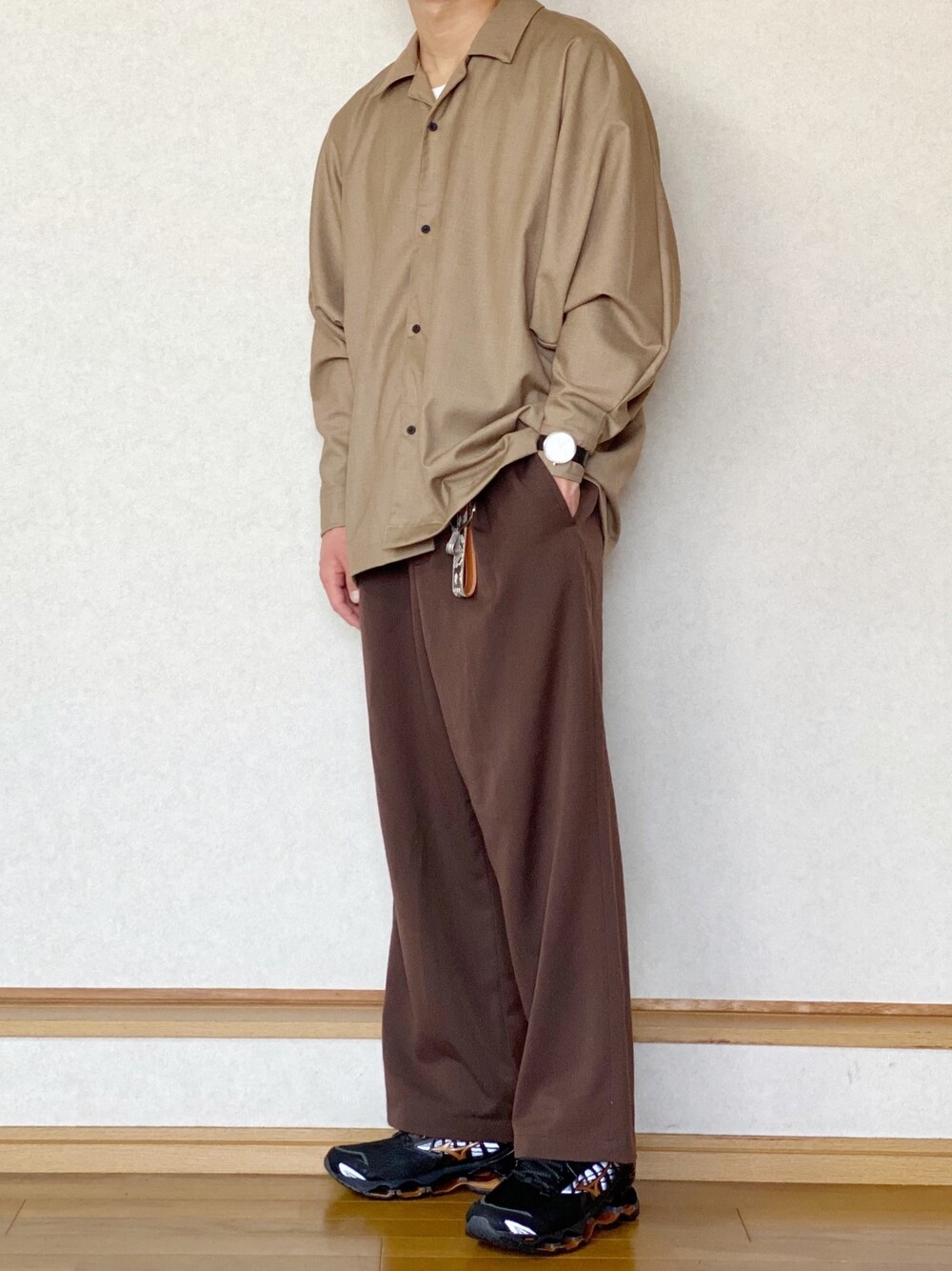 ベージュ系のシャツ/ブラウス、ブラウン系のスラックス、ブラック系のスニーカーを着用したメンズの春コーディネートの1枚目の写真
